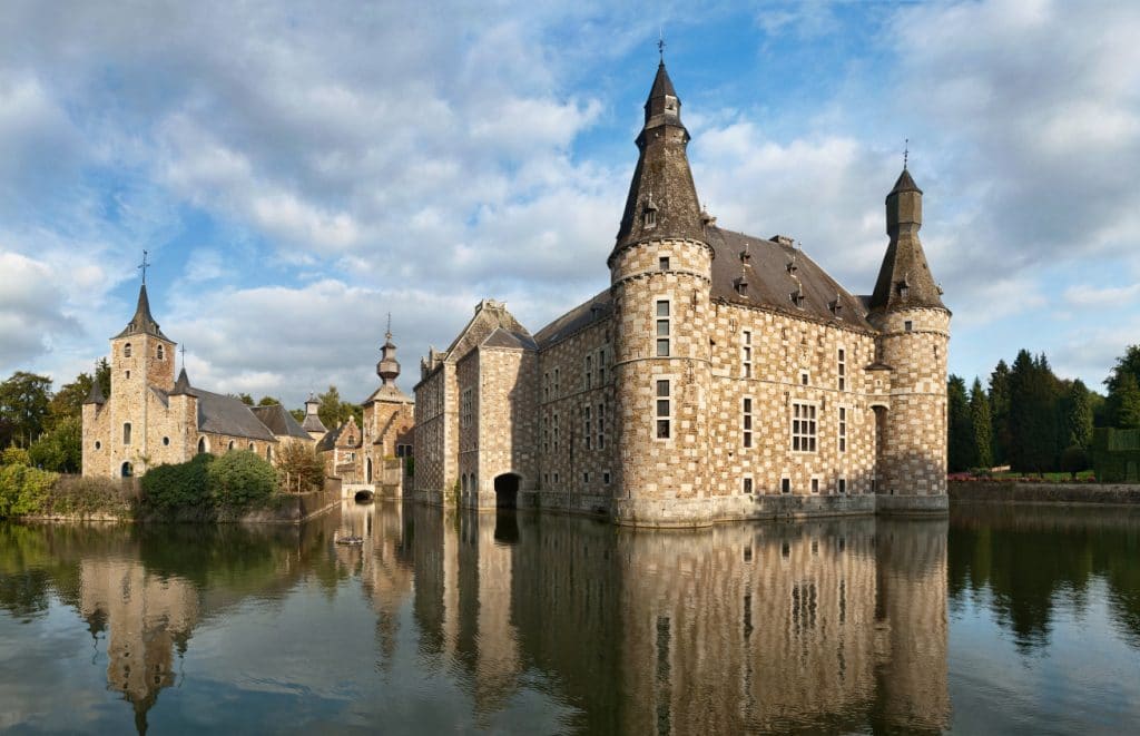 châteaux wallonie, ici le château de Jehay avec ses douves, extérieur façades briques et toit pointu gris à tours